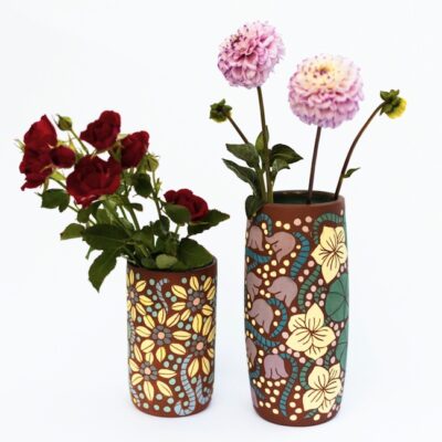 These tall, cylindrical vases thrown on the wheel using Navaho clay. I then hand painted floral motifs and carved details before drying and firing. I then glazed the inside a vibrant turquoise for a nice contrast to hold large blooms.